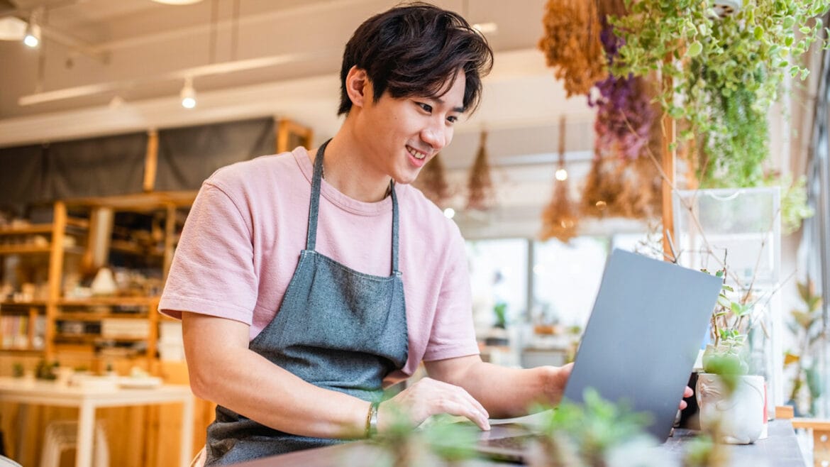 SME business owner using laptop in a café setting, representing digital operations supported by reliable broadband