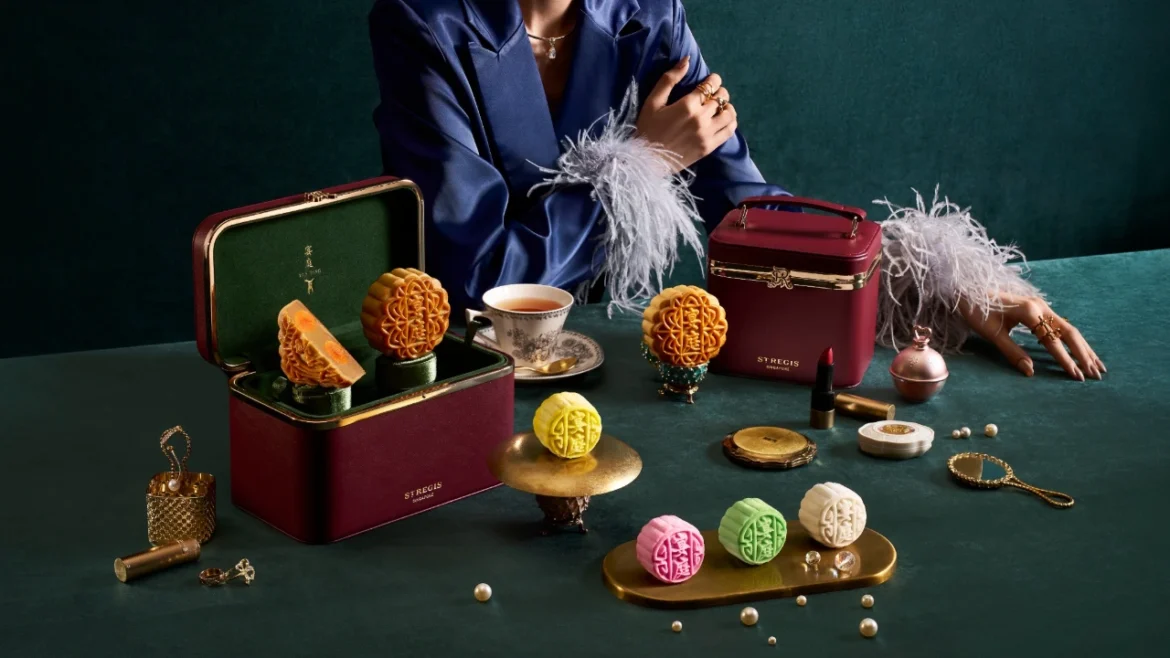 The St. Regis Singapore 2026 baked and mini snowskin mooncakes displayed with burgundy leather bags