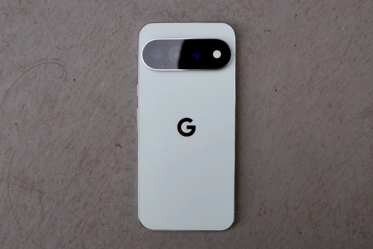 Top-down view of a white Google Pixel 11 Pro XL lying face-down on a grey surface.