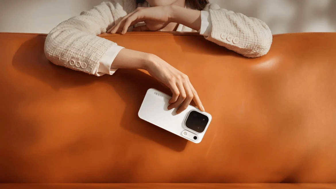 A person holding a white OPPO Find X10 Pro Max over an orange leather sofa.