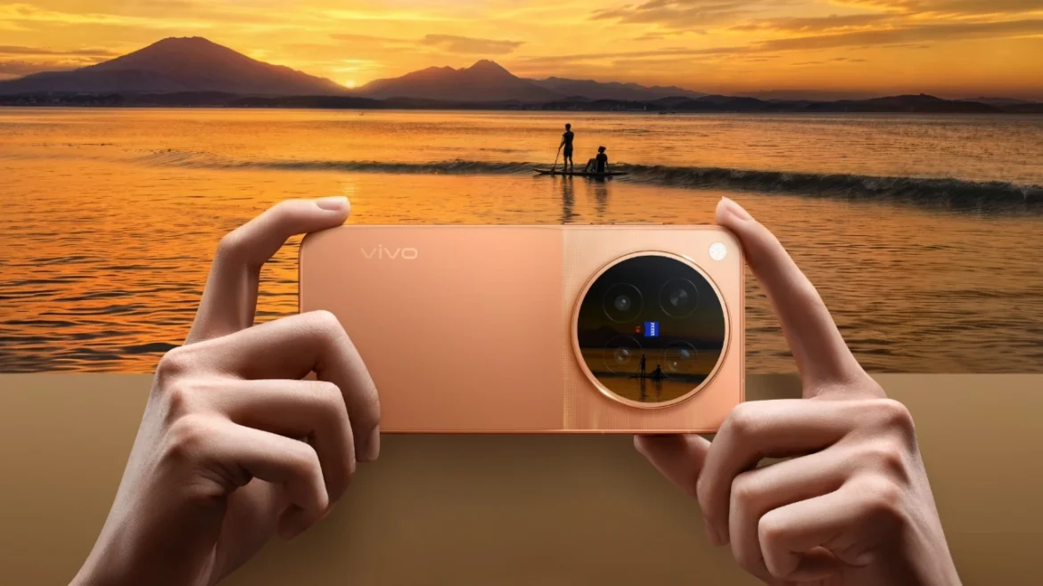 Sunset Orange vivo X500 Pro Max held horizontally in front of a golden sunset over water.